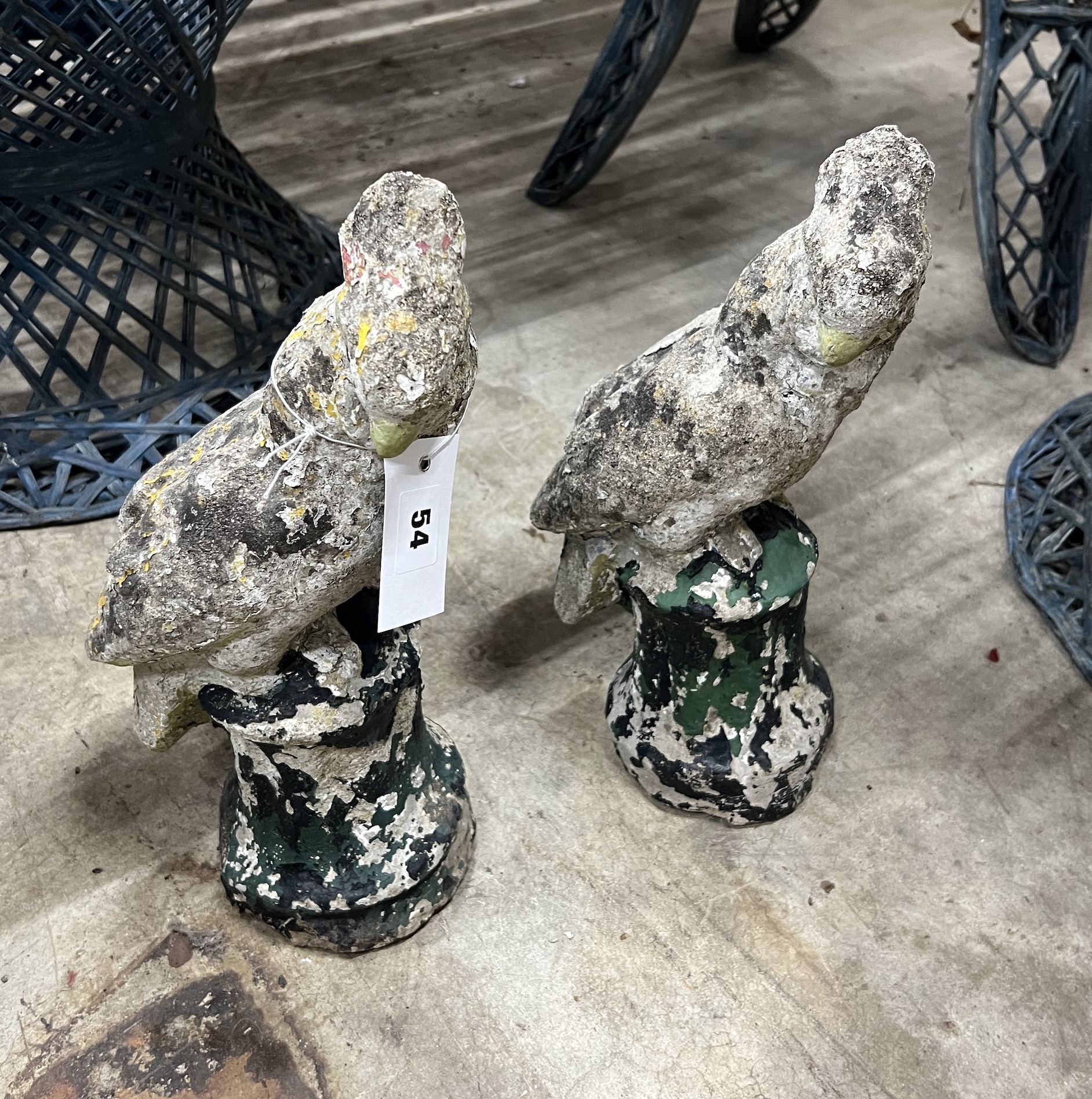 A pair of reconstituted stone parrot garden ornaments, height 32cm